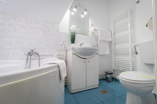 baño blanco con lavamanos y aseo en Vila Mărioara en Sibiu