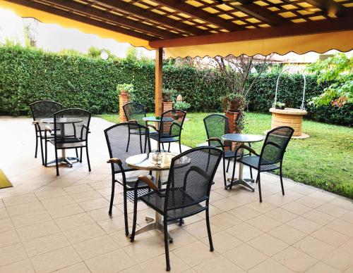 un grupo de mesas y sillas en un patio en B&B Villa Primavera, en Pisa