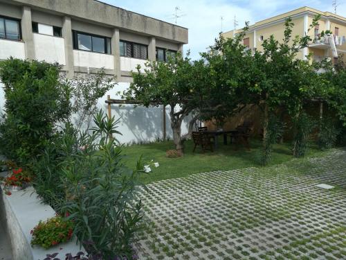 a garden with a table and trees in front of a building at Piccolo Bed in Procida
