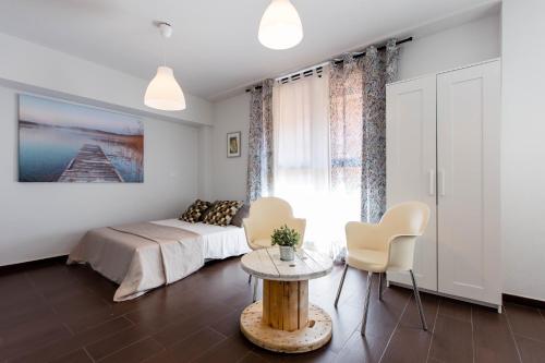 sypialnia z łóżkiem, stołem i krzesłami w obiekcie 2 habitaciones Apartamento Temporada en Lucero w Madrycie
