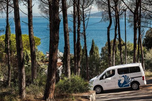 a white van parked on a road next to trees at Grifo Hotel Charme & SPA in Ischia