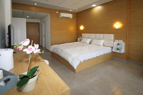 ein Schlafzimmer mit einem Bett und einem Tisch mit einer Blume in der Unterkunft סנו נופש בגולן in Madschdal Schams