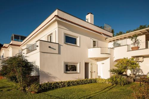 a large white house with a grass yard at Grifo Hotel Charme & SPA in Ischia