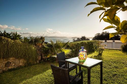 a table and chairs with a vase on top of it at Grifo Hotel Charme & SPA in Ischia