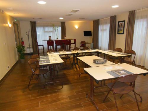 a room with tables and chairs and a dining room at Campanile Nevers Nord - Varennes-Vauzelles in Varennes Vauzelles
