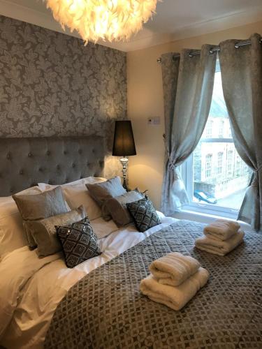 a bedroom with a large bed with two towels on it at Millwalk Apartment in Witney