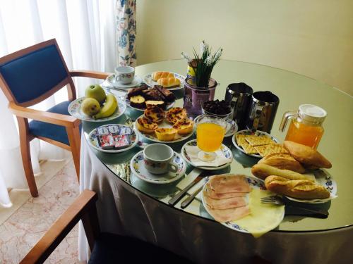 a table full of breakfast foods and orange juice at Hotel Caldelas in Caldelas
