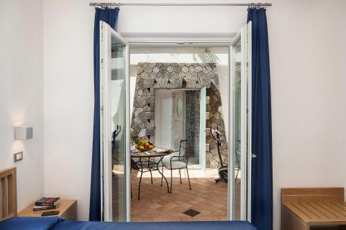 a room with a door open to a room with a table at Grifo Hotel Charme & SPA in Ischia