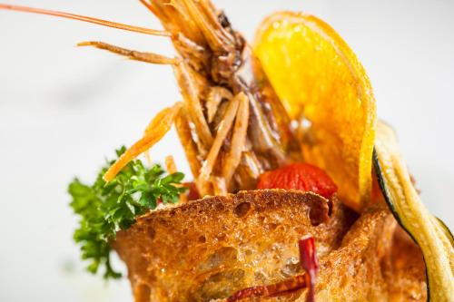 a plate of food with a lobster and a slice of bread at Grifo Hotel Charme & SPA in Ischia