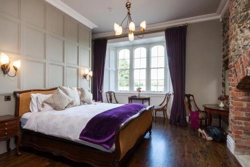 a bedroom with a bed with a purple blanket on it at Wilton Castle in Enniscorthy