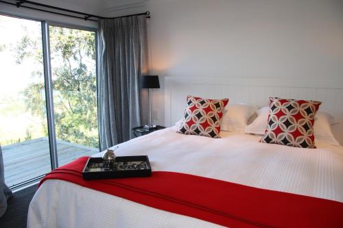 a bedroom with a large bed with a large window at Acacia Cliffs Lodge in Taupo