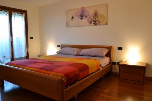 ein Schlafzimmer mit einem Bett mit einer bunten Decke in der Unterkunft Alice 12 Flat - Apartment in Bollate