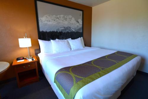 a large bed in a hotel room with a lamp at Super 8 by Wyndham Port Angeles at Olympic National Park in Port Angeles