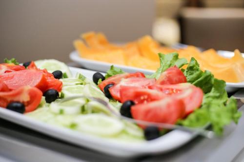 a plate of salad with tomatoes and olives and cheese at Old Town Hotel in Sarajevo