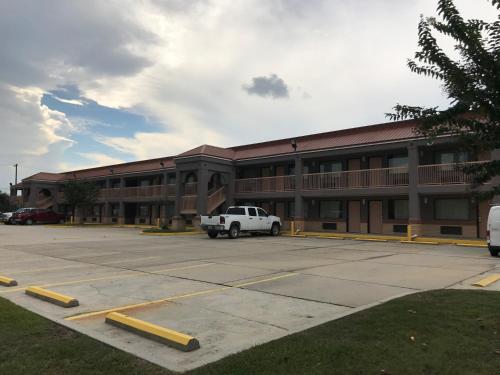 a white truck parked in a parking lot in front of a building at Super 8 by Wyndham Slidell in Slidell