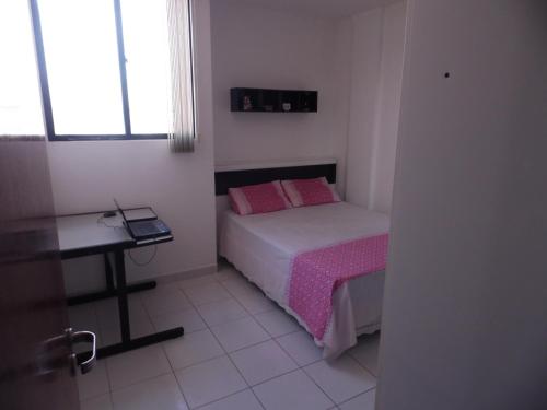 a small bedroom with a bed and a table at Apartamento para temporada in Campina Grande
