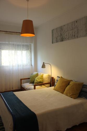 a bedroom with a large bed and a couch at Mary's House in Carnaxide
