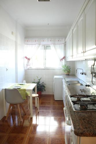 a kitchen with a table and a stove top oven at Mary's House in Carnaxide