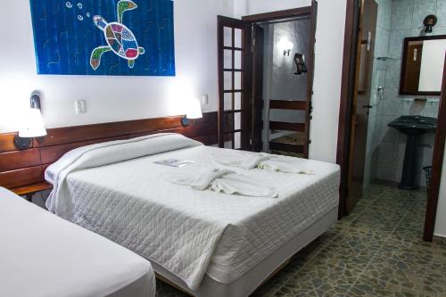 a bedroom with a bed and a painting on the wall at Pousada Torre Del Mar in Ubatuba