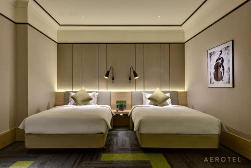 a hotel room with two beds and a table at Aerotel Singapore - Transit Hotel in Terminal 1 in Singapore