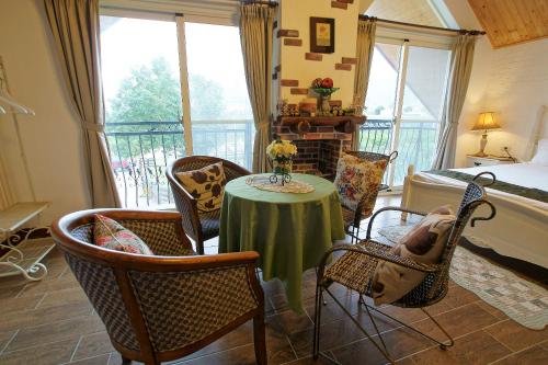 a room with a table and chairs and a balcony at Hou Niao Fei Xing B&B in Taiping