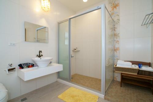 a bathroom with a glass shower and a sink at Hou Niao Fei Xing B&B in T'ai-pin-ts'un