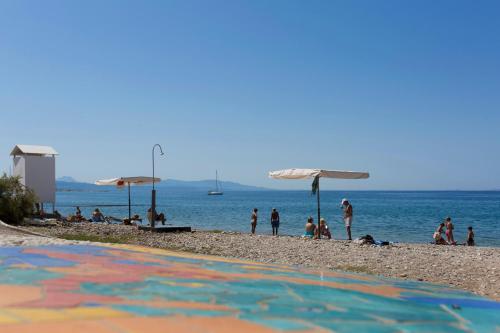 a group of people on a beach with umbrellas at Delfini Hotel in Patra