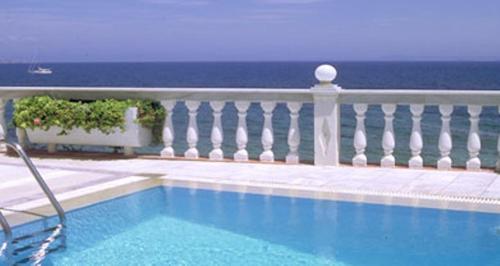 una piscina accanto a un balcone con vista sull'oceano di Ostria Seaside Studios and Apartments a Katarráktis