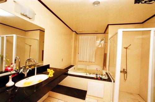 a bathroom with a sink and a bath tub at 意大利商務溫泉汽車旅館 in Jiaoxi
