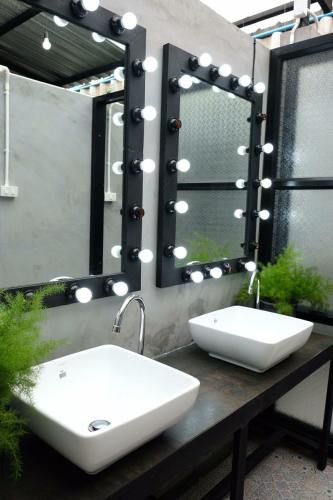 a bathroom with a sink and a mirror at THE TREE Sleep and Space in Trang