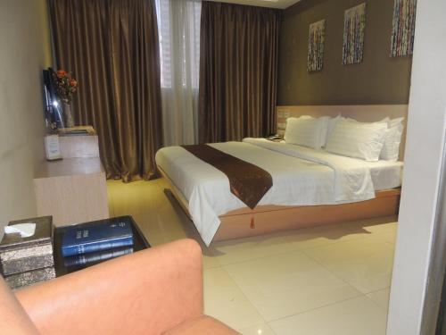 a hotel room with a bed and a chair at Dela Chambre Hotel in Manila
