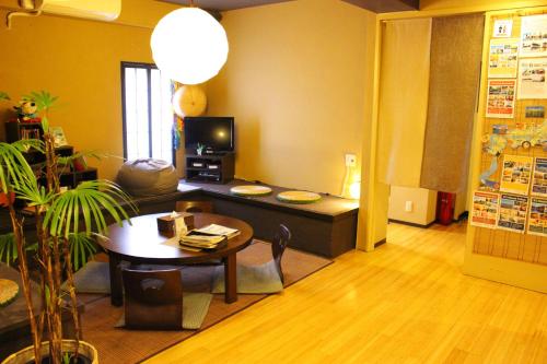 a living room with a table and a couch and a tv at K's House Tokyo Oasis - Asakusa Downtown in Tokyo