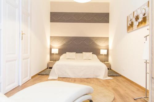 a white bedroom with two beds and two lamps at Luxury 2BR Apt by the Synagogue in Budapest