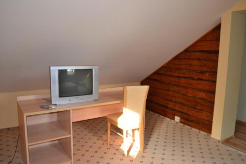 a room with a desk with a tv and a chair at Vila Evelina in Druskininkai