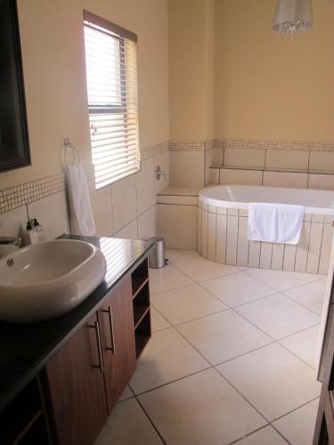 a white bathroom with a tub and a sink at 398 Vaal de Grace Golf Estate in Parys