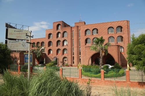 a red brick building with a fence in front of it at Magsons Resorts in Vrindāvan