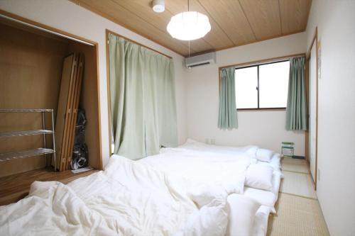 a bedroom with a white bed and a window at Nagomiya Kyoto Minami-Enmachi in Kyoto