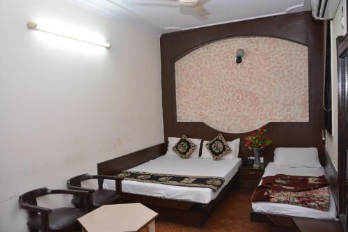 a small room with two beds and a window at Hotel Yatri International in New Delhi