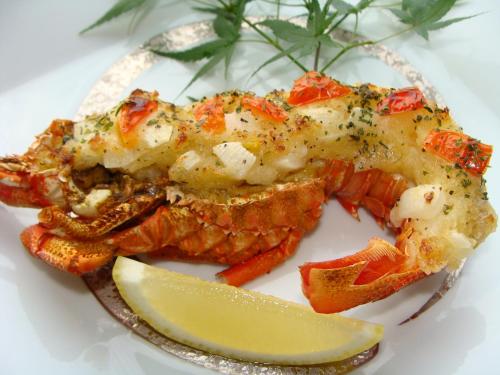 a plate of food with lobster and a slice of lemon at Hamazen Ryokan in Hinagu