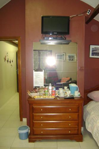 a bedroom with a dresser and a tv on a wall at Le Castillon in Trivières