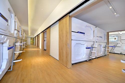 a hallway with white washers and dryers in a room at Grand Whiz Hotel Trawas Mojokerto in Trawas