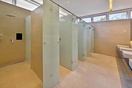トラワスにあるGrand Whiz Hotel Trawas Mojokertoのトイレと洗面台が一列に並んだバスルーム