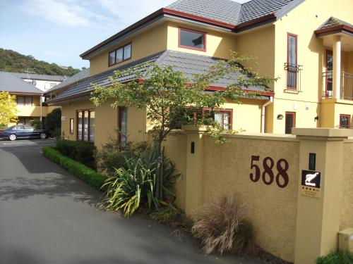 a yellow house with a sign that says at Alhambra Oaks Motor Lodge in Dunedin