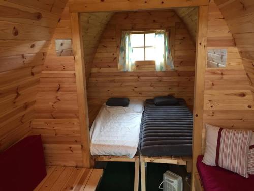 a small room with a bed in a log cabin at Camping Le pommier rustique in Yvoir