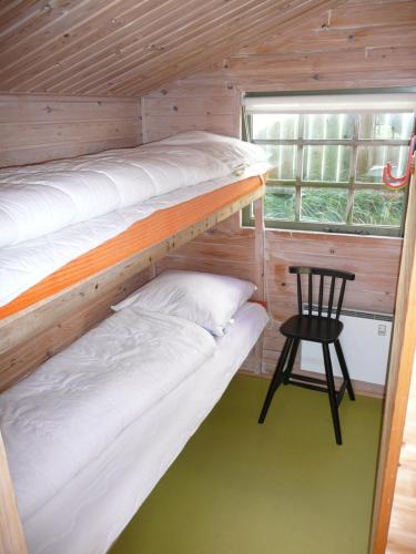 Tempat tidur dalam kamar di Lønstrup Camping Cottages & Rooms