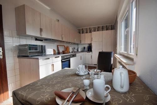 a kitchen with a table with plates and utensils on it at Gästehaus Spengler in Celle