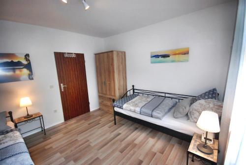 a bedroom with a bed and two tables and two lamps at Gästehaus Spengler in Celle