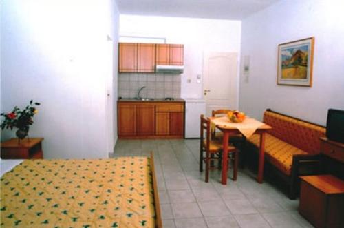 a room with a kitchen and a table and a dining room at Ionion Hotel in Syvota