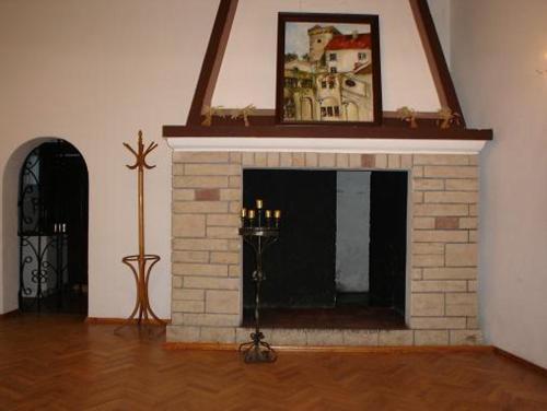 a living room with a fireplace with a picture above it at Zamek Otmuchów in Otmuchów