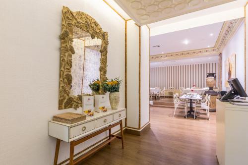 a room with a mirror on the wall and a table at Luna Hotel da Oura in Albufeira